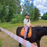 Na zdjęciu widzimy dziecko na koniu podczas przejażdżek konnych na Dniu Dziecka w Orchówku.