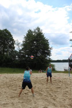 Na zdjęciu widzimy dwóch uczestników turnieju piłki siatkowej plażowej na boisku nad Jeziorem Białym.